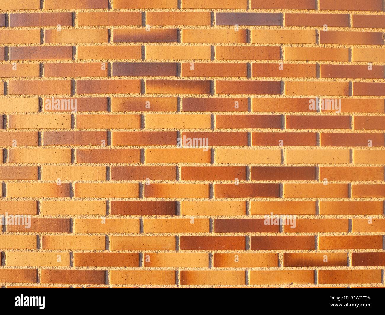 Orange brick facade creating a uniform brickwork pattern backdrop Stock Photo