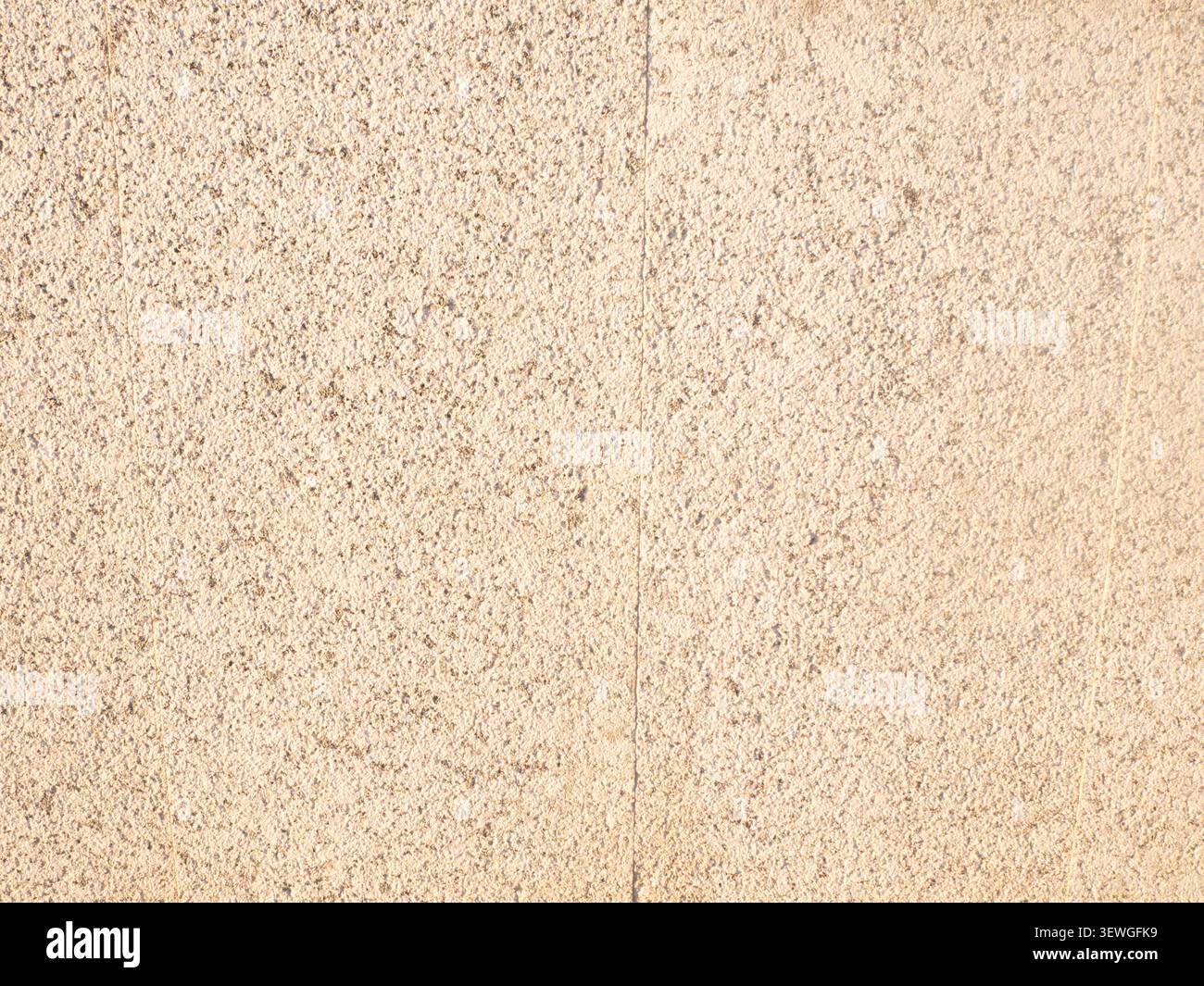 Rough beige concrete wall surface showing a textured background Stock Photo