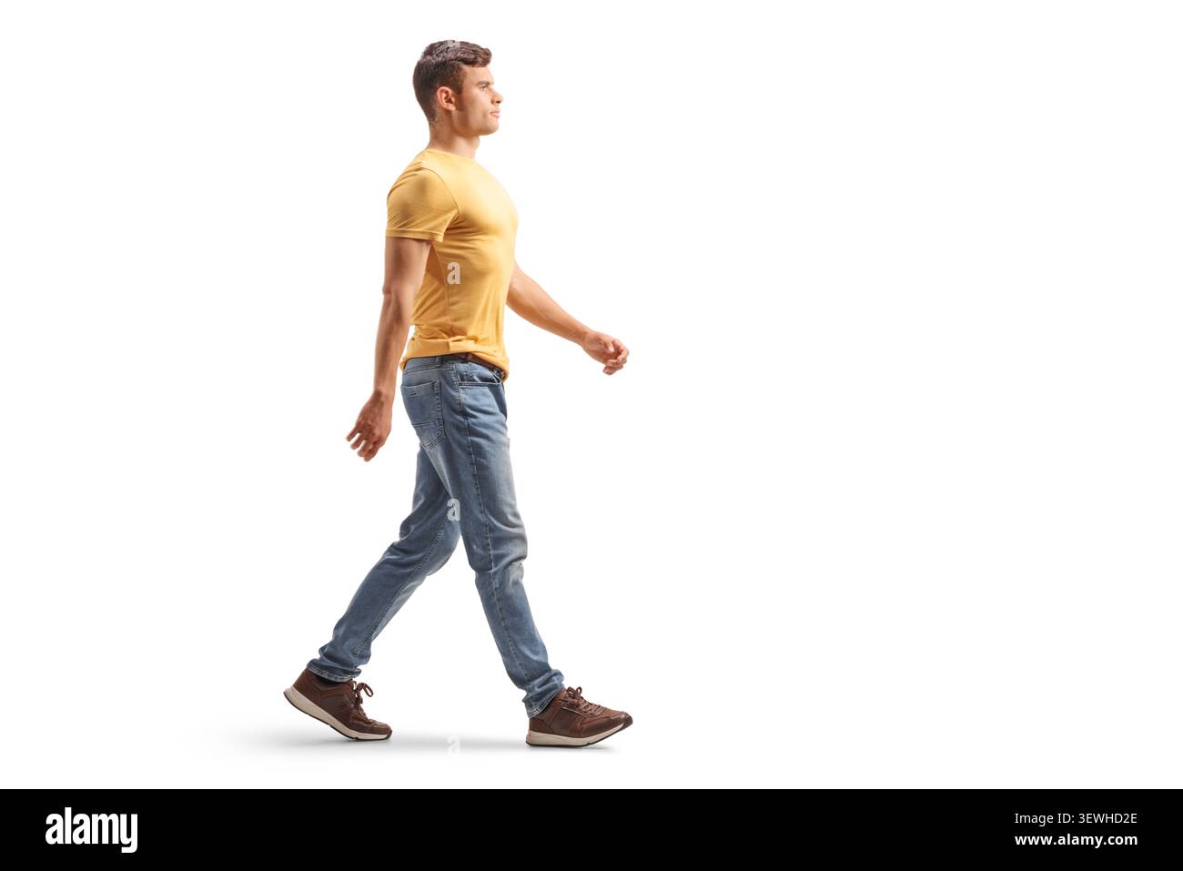 Young man walking in profile view isolated on white background Stock Photo
