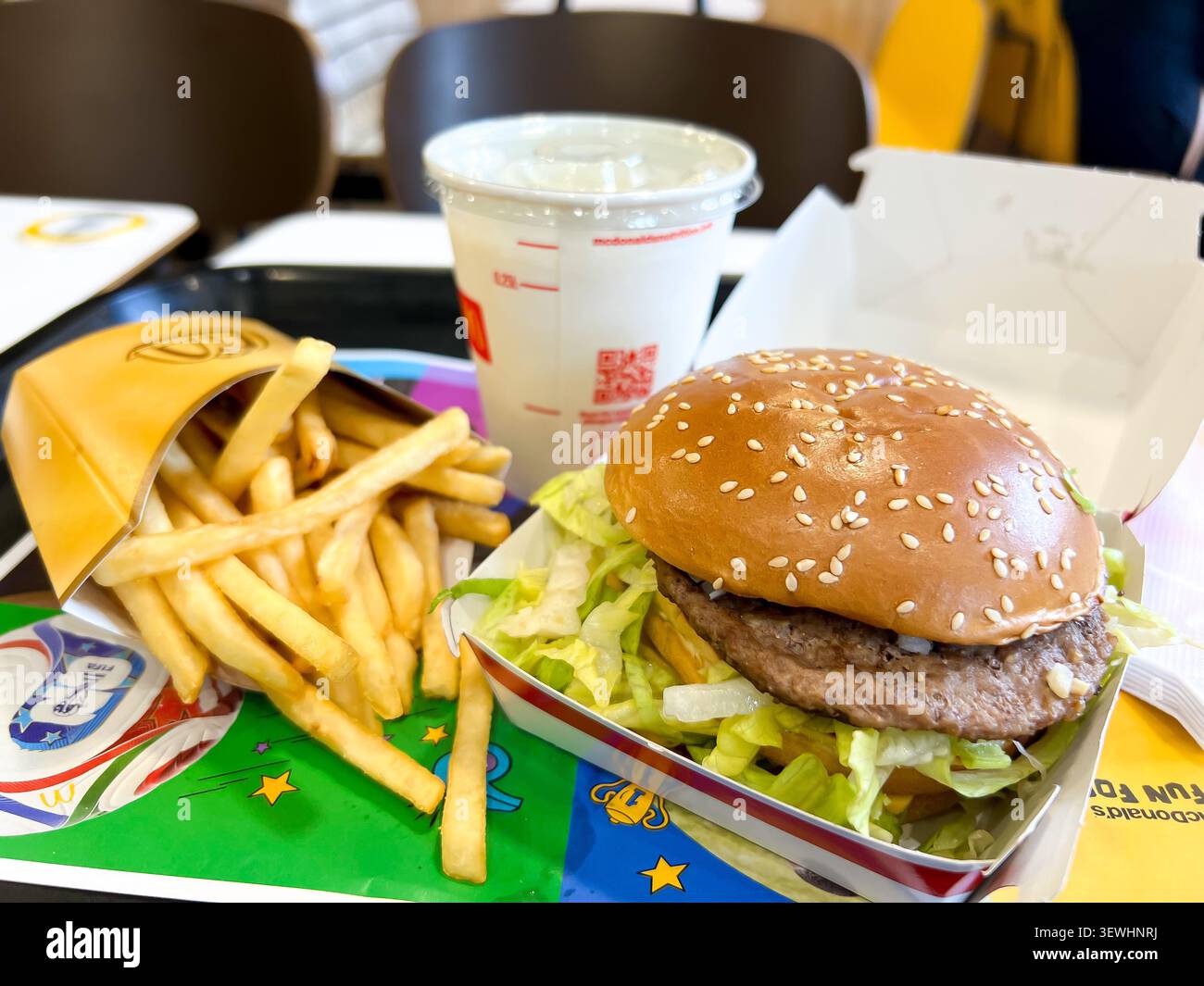 Close up view of a medium sized portion of McDonalds fries and a Big Mac hamburger in special World Cup packaging with banana milkshake for lunch - Smartphone Captured Stock Image