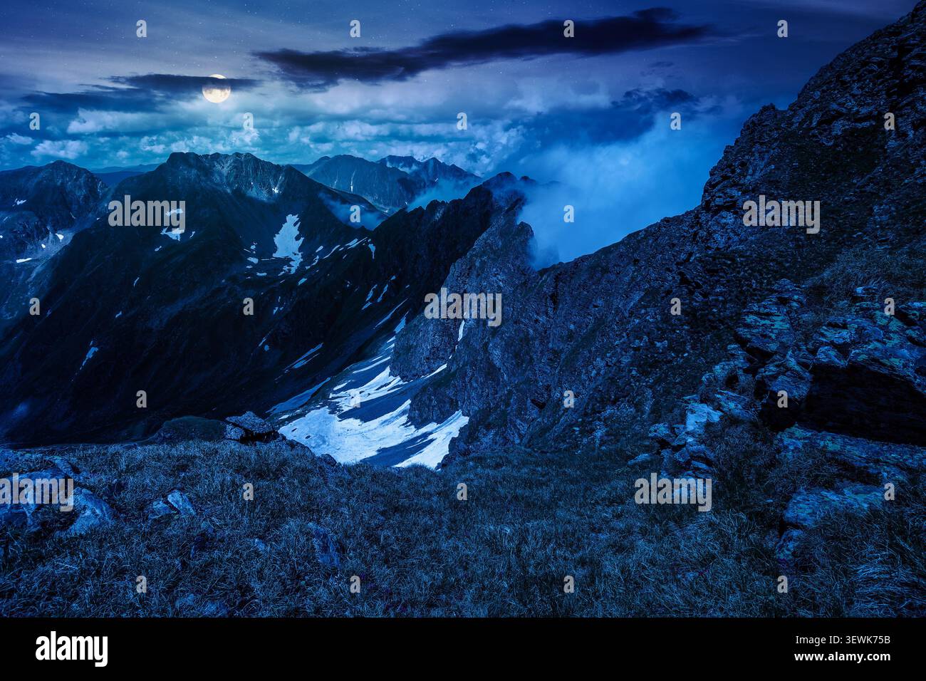 romania mountain landscape in summer at night. full moon over travel background of alpine scenery in fagaras mountain ridge. european summer outdoor a Stock Photo