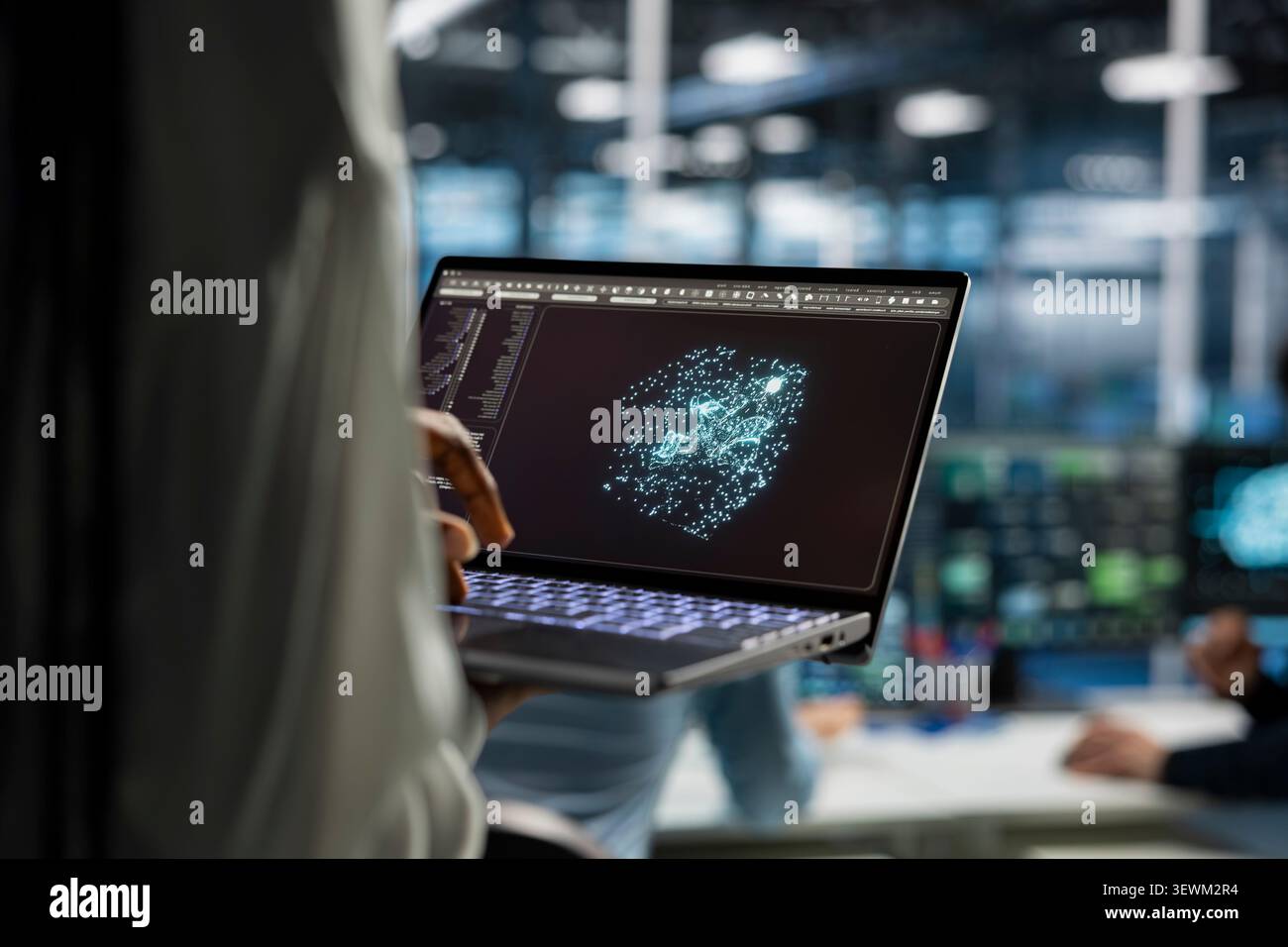 Engineer works with a laptop in a server hub to support artificial intelligence systems. Stock Photo