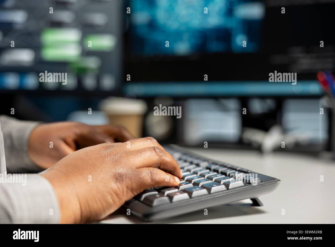 Data center programmer uses a desktop computer in a data center to manage AI systems and optimize server infrastructure. Stock Photo