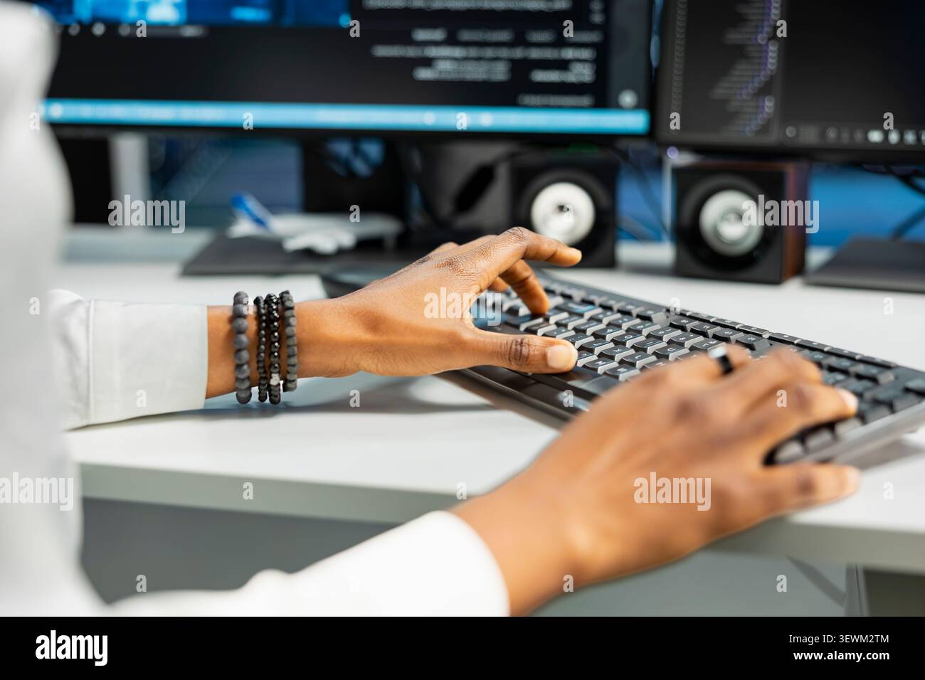 Computer scientist works with desktop computer in a data center to support data processing, analytics, and storage infrastructure. Stock Photo