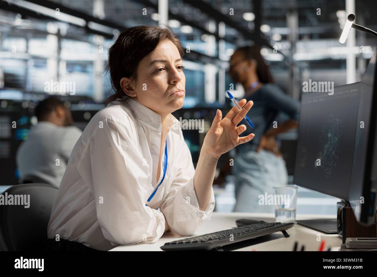 Data center engineer uses a desktop computer in a data center to support failure detection and reliable server workflows. Stock Photo