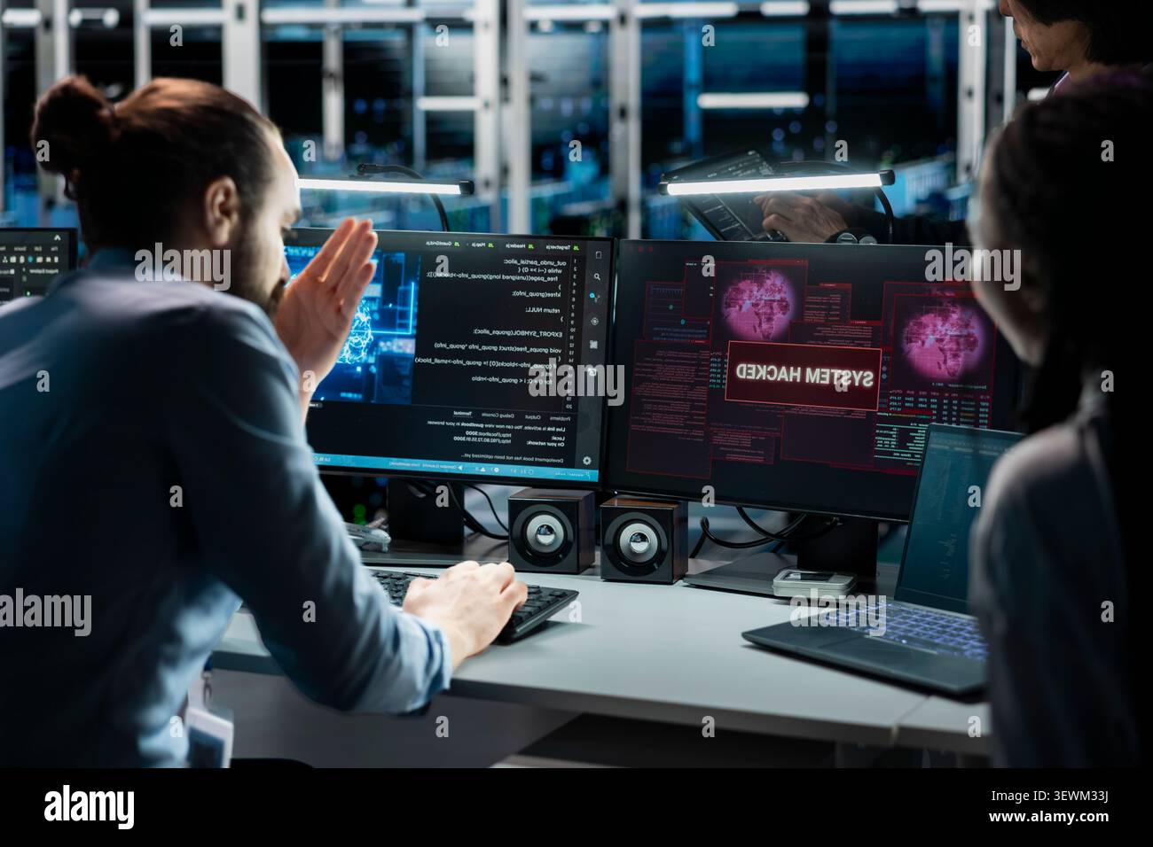 Pensive data center technicians review system data in a data center while planning repairs for performance and hardware issues. Stock Photo