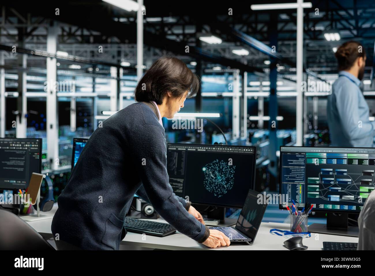 Software developer inspects server infrastructure, performs maintenance checks and reviews equipment diagnostics. Stock Photo
