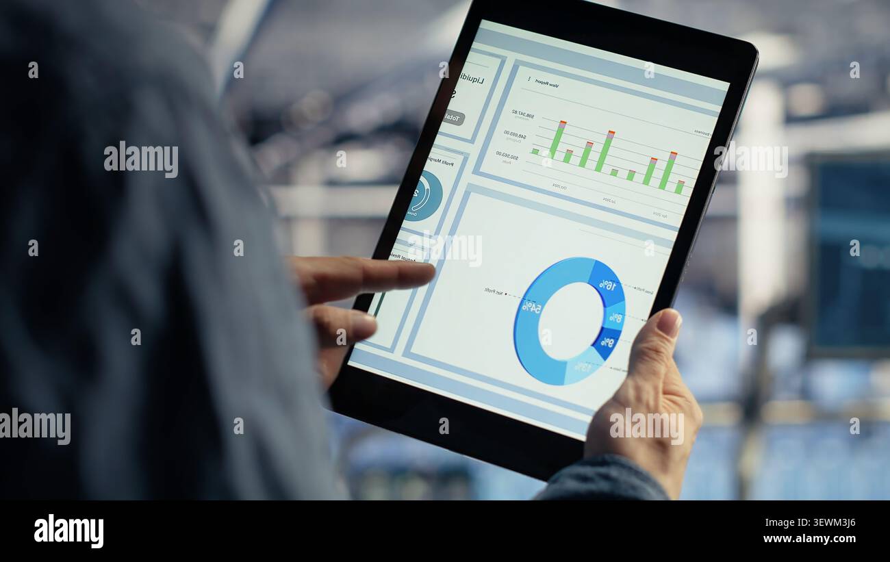 Data center worker uses a tablet to run diagnostics, update servers and check infrastructure performance. Stock Photo