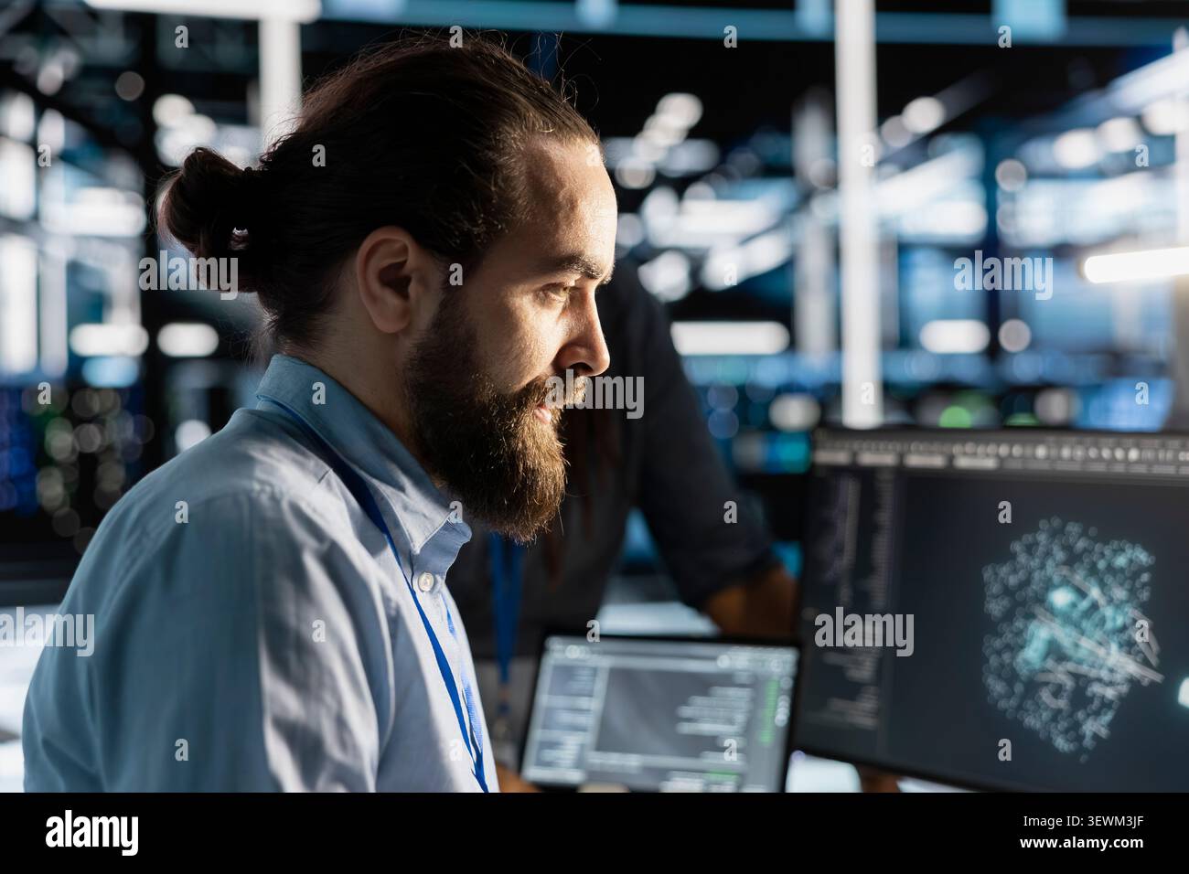 Data center technician uses a computer to run diagnostics, update servers and check infrastructure performance. Stock Photo