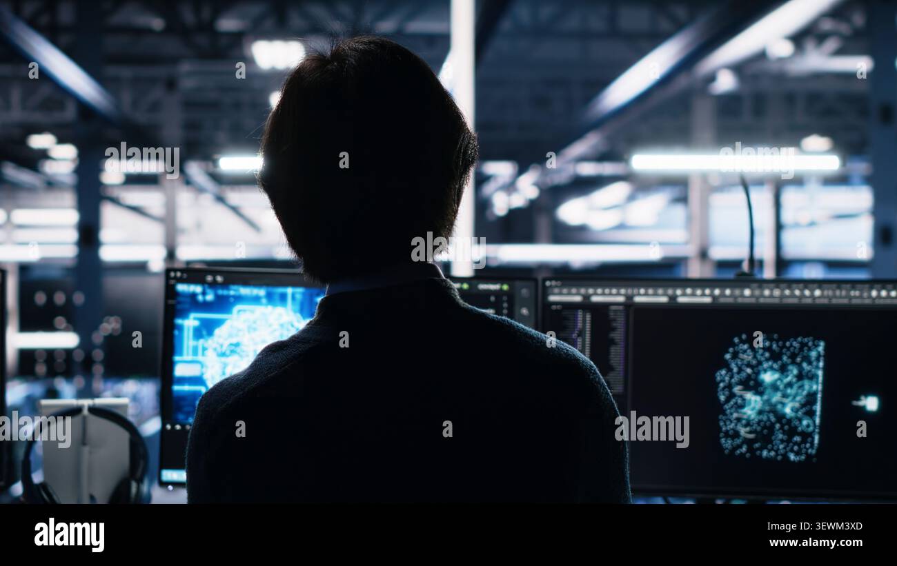 System administrator reviews artificial intelligence systems and machine learning processes inside a data center. Stock Photo