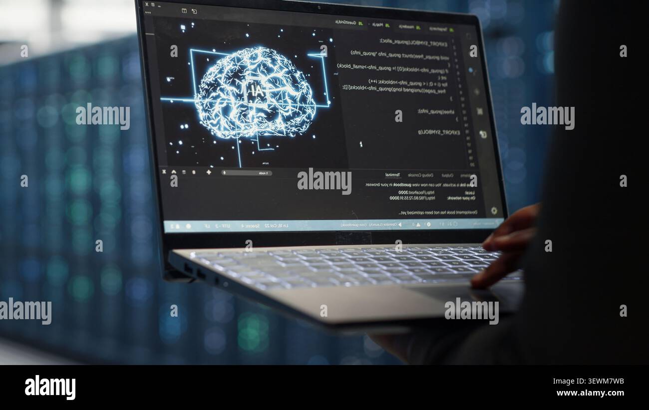 Computer scientist uses laptop-based deep learning tools in a server room to improve AI operations and system efficiency. Stock Photo