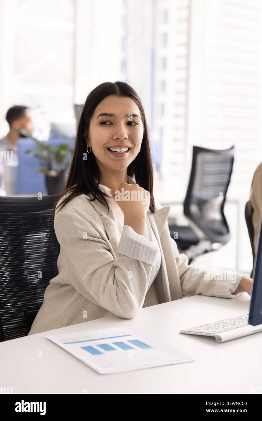 Happy young woman working at modern office desk Stock Photo