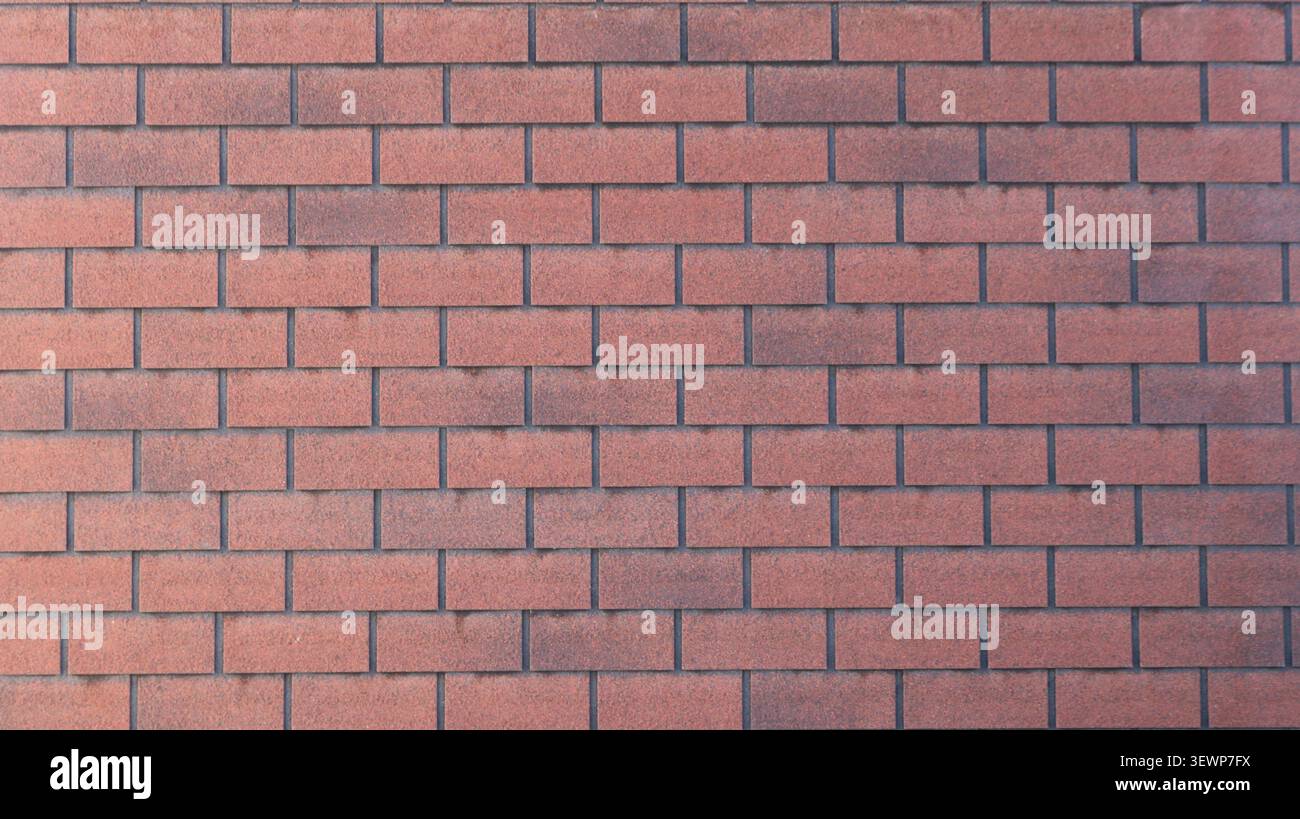 texture of a smooth wall lined with red decorative brick. The tiles have a fine-grained texture with a gradient from terracotta to dark brown. Stock Photo