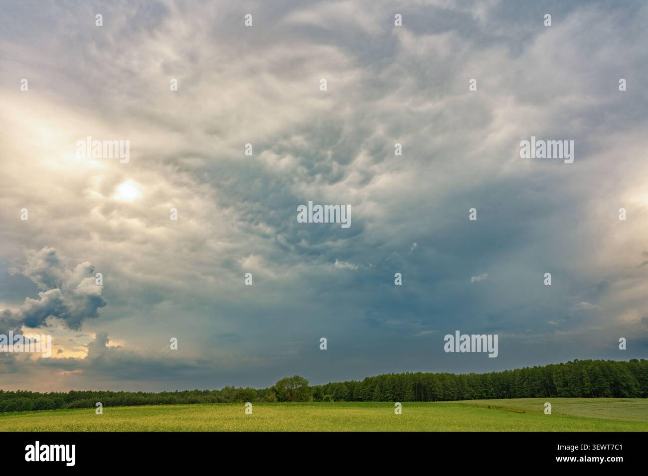 Dramatic storm clouds over green countryside landscape before rain Stock Photo