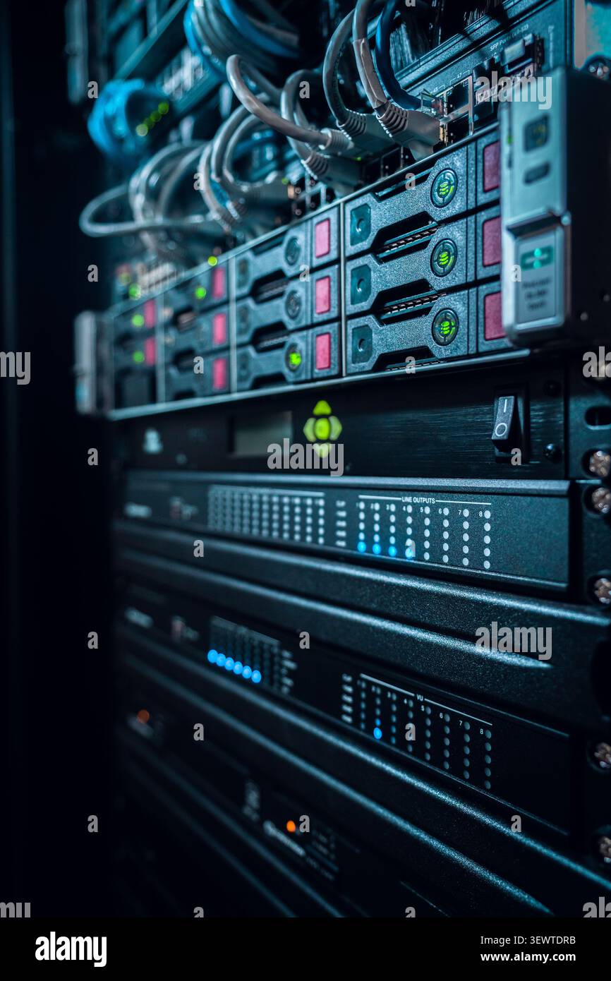 View of a server rack with blinking status lights, network cables, and hardware components in a data center in Los Angeles, California, United States. Stock Photo