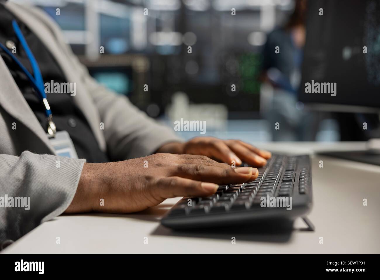 Data center technician uses a desktop computer in a data center to run hardware diagnostics and maintain operational stability. Stock Photo