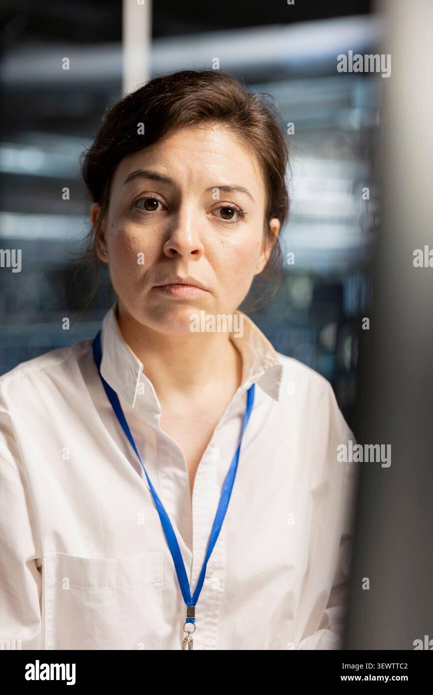 Software developer reviews performance analytics on a computer in a data center to optimize storage systems and resource use. Stock Photo