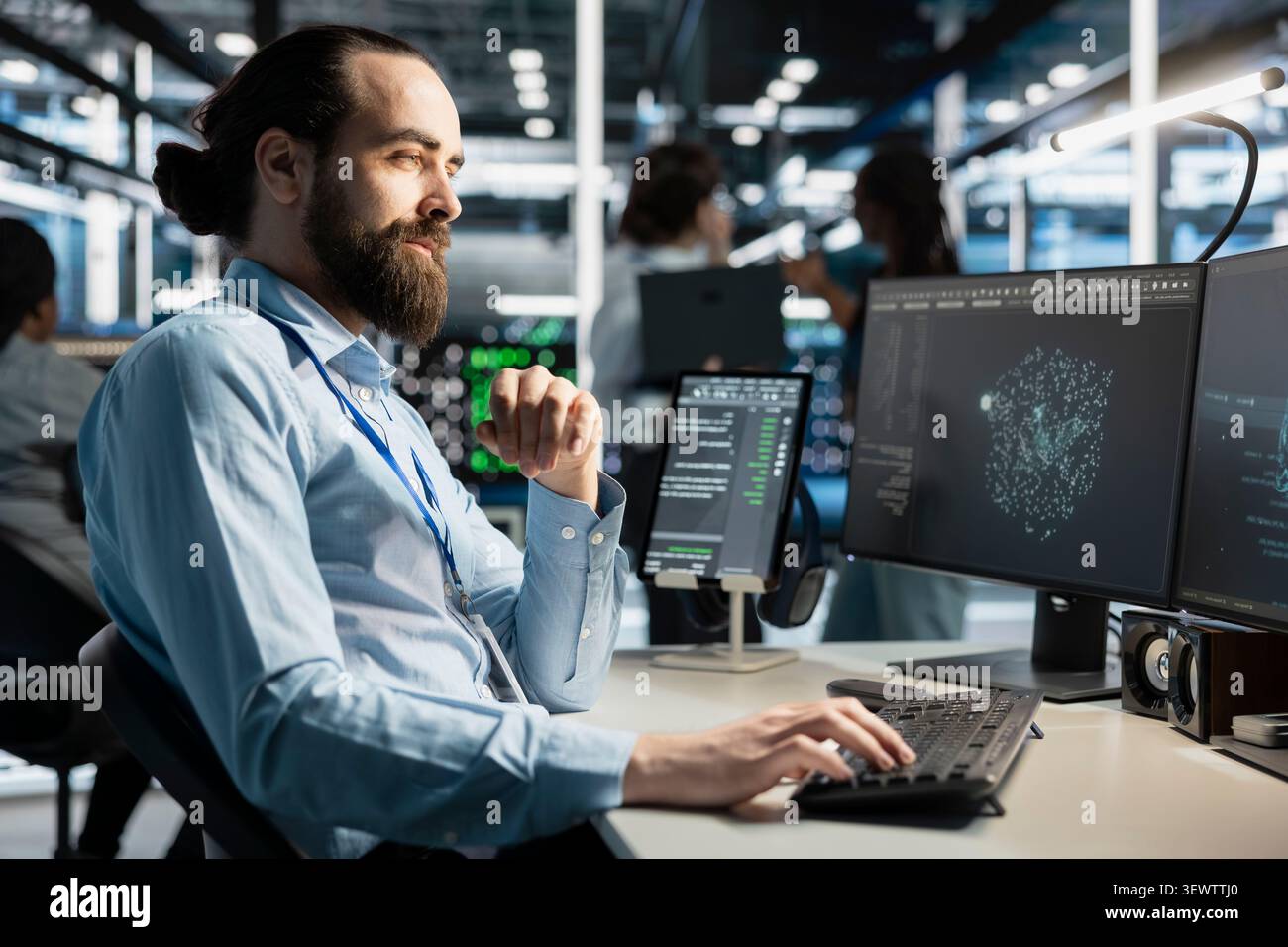 Data center technician uses a computer to run diagnostics, update servers and check infrastructure performance. Stock Photo