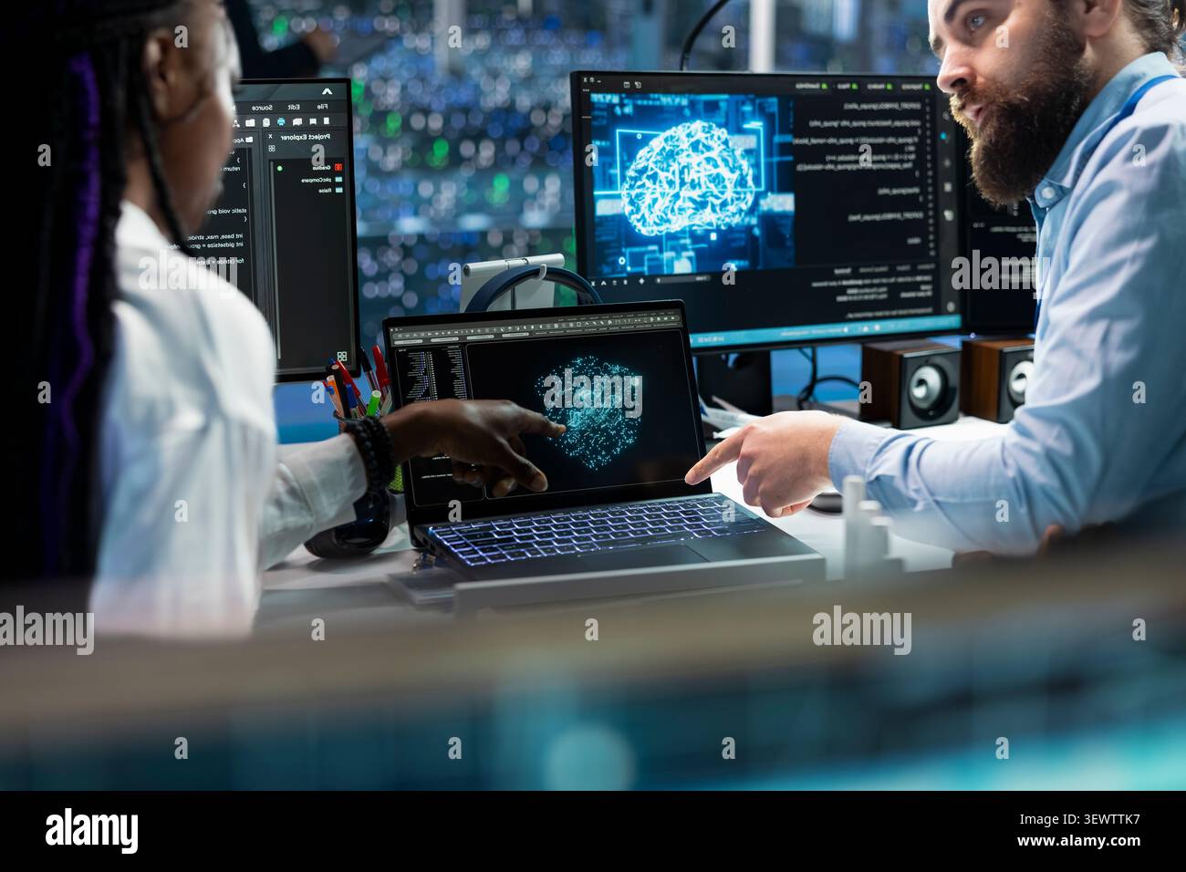 Data center colleagues collaborate on coding and AI automation scripts while reviewing server infrastructure together. Stock Photo