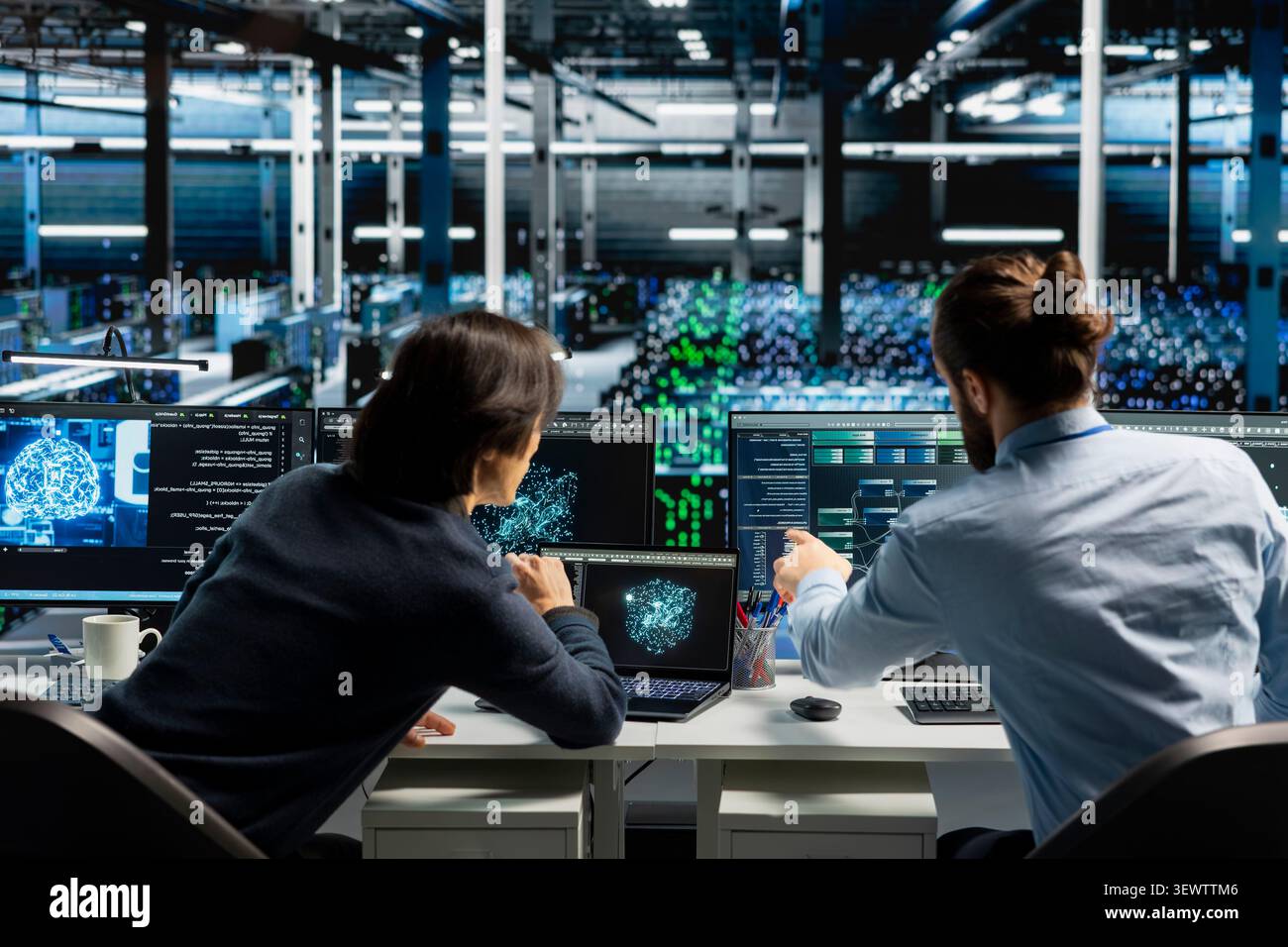 System administrator reviews artificial intelligence systems and machine learning processes inside a data center. Stock Photo