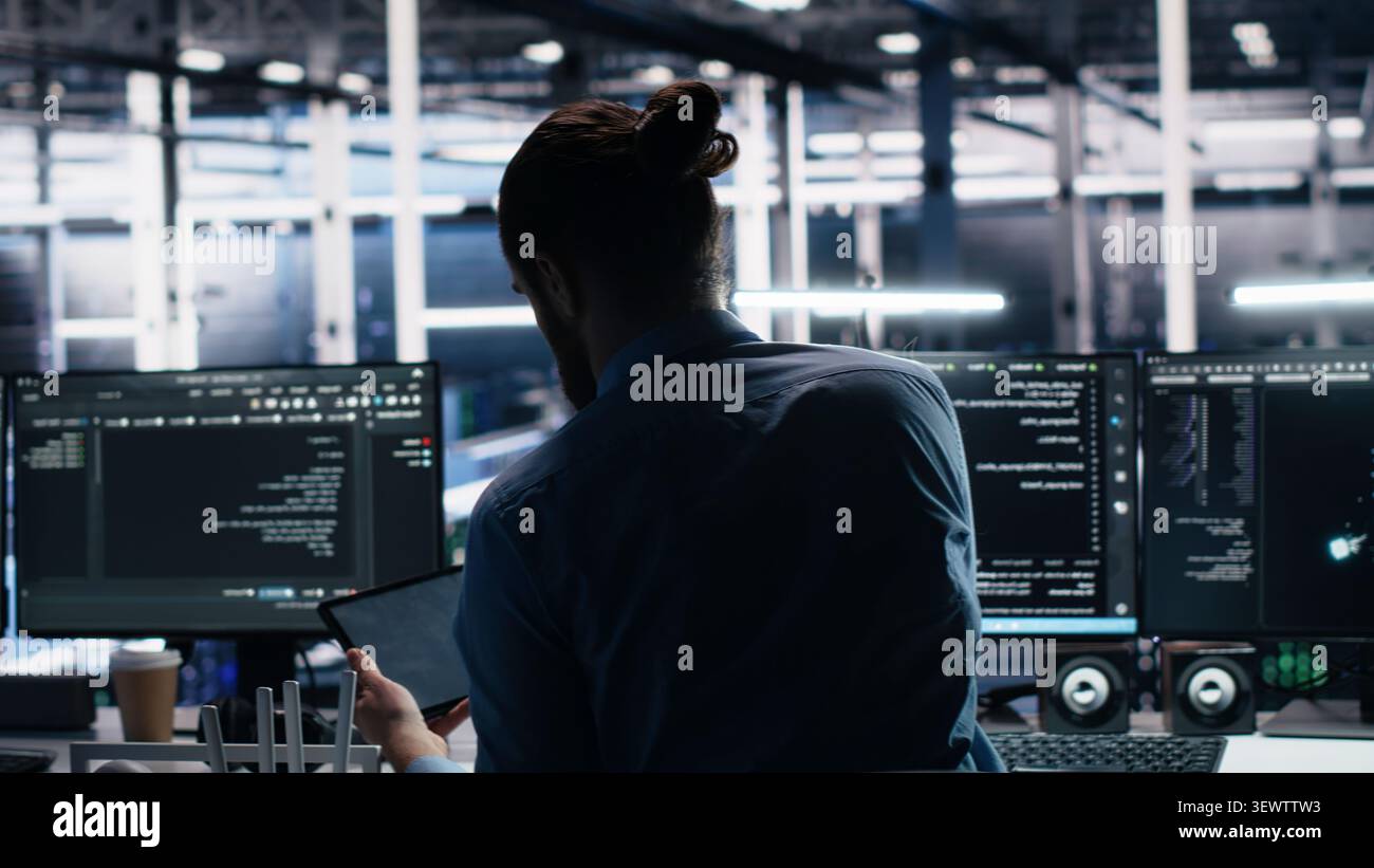 Administrator programs on a laptop in a data center with generative AI assistance. Stock Photo