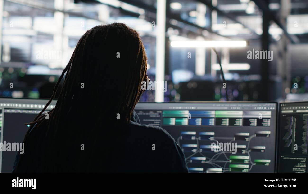 Data center engineer reviews artificial intelligence systems and machine learning processes inside a data center. Stock Photo
