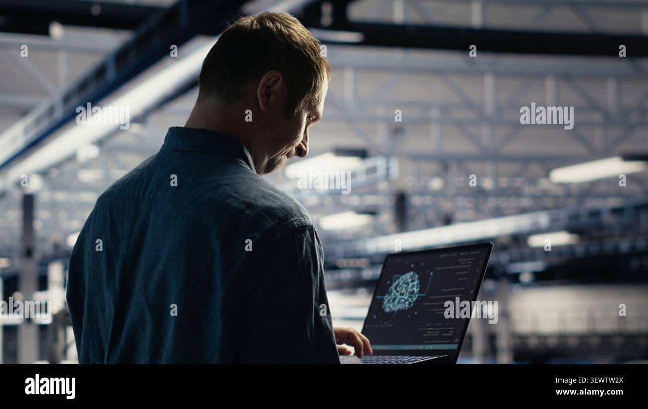 Technician monitors server room activity working with laptop while walking through facility. Stock Photo