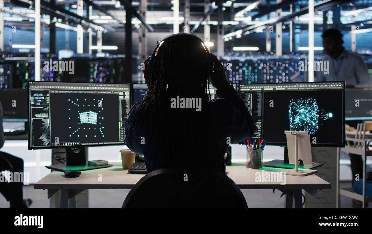 High tech server room technical specialist implements AI virtualization frameworks to enhance server clusters, while IT professional doing AI predictive analysis. Stock Photo