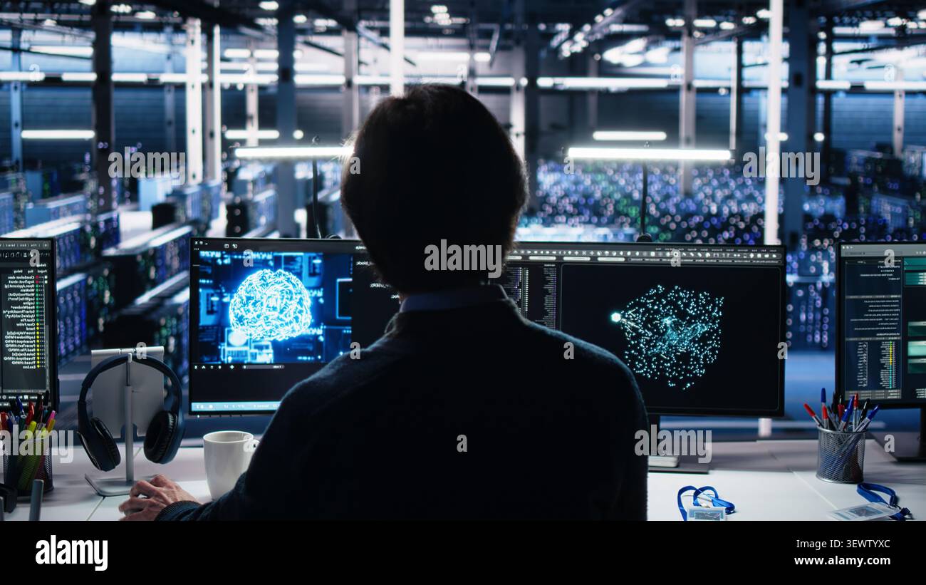 Software developer programs on a computer workstation in a server farm with generative AI assistance. Stock Photo