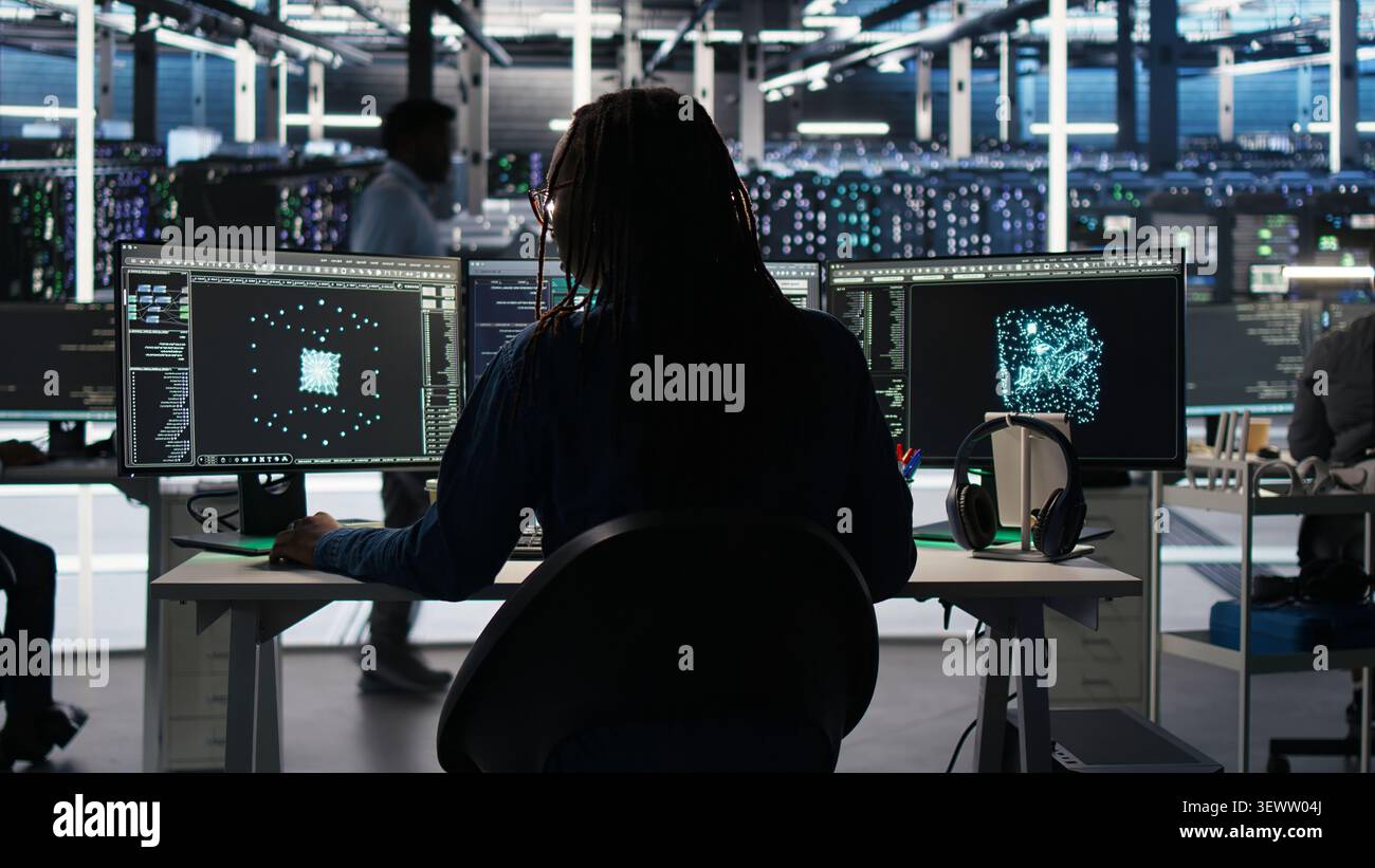 Server room software programmer interpreting AI generated data analytics graphs, wearing headphones, while operates AI tool showing system metrics, listening music. Stock Photo