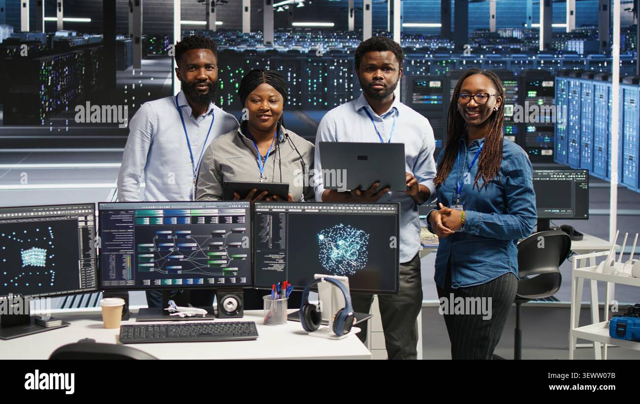 Friendly high tech server room technicians assessing digital infrastructure issues. Stock Photo