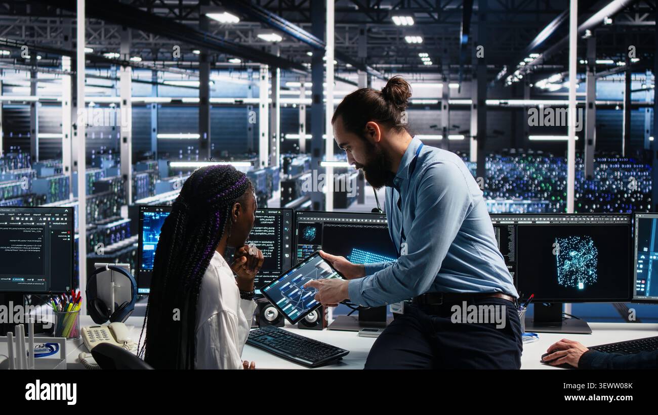 Data infrastructure center engineering team members collaborating on neural network software development, while implementing machine learning technology in workplace. Stock Photo