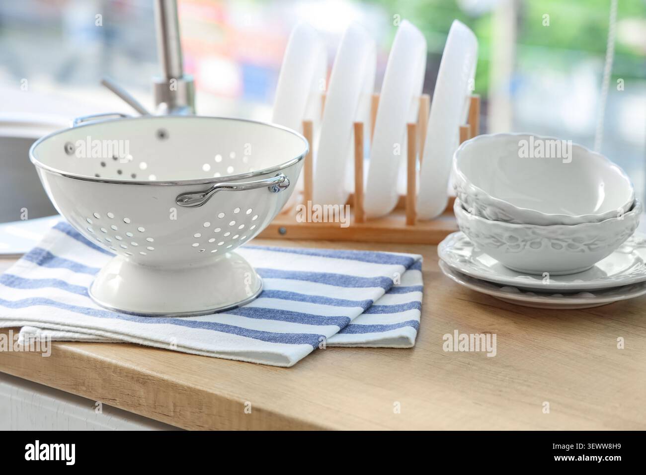 Clean kitchenware drying on wooden countertop Stock Photo