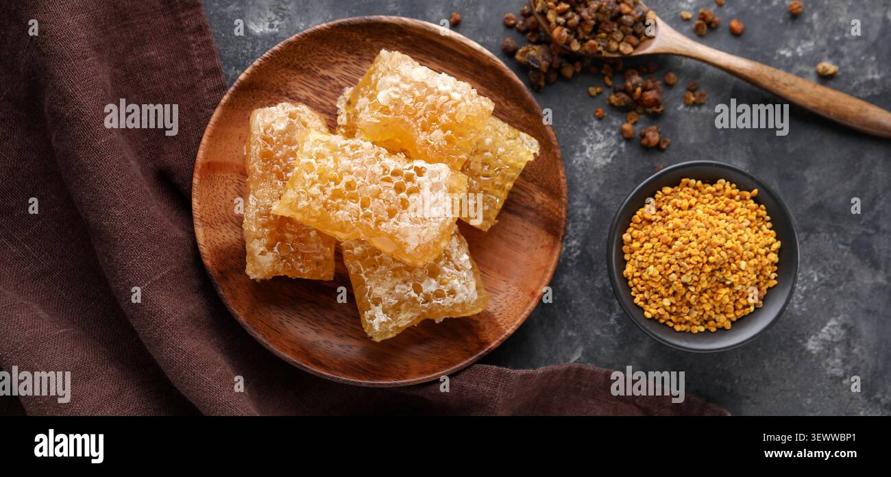 Honeycomb pieces with bee pollen on dark surface Stock Photo
