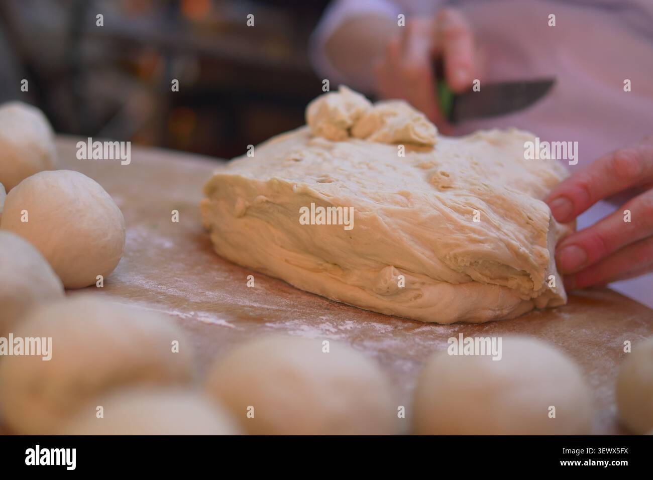 Baker kneads dough and prepares for bread making in kitchen Stock Photo