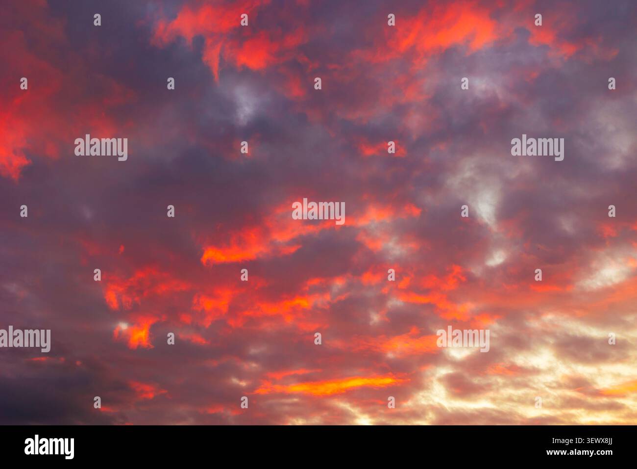 Orange sunset sky background. Dramatic partly cloudy sky view. Stock Photo