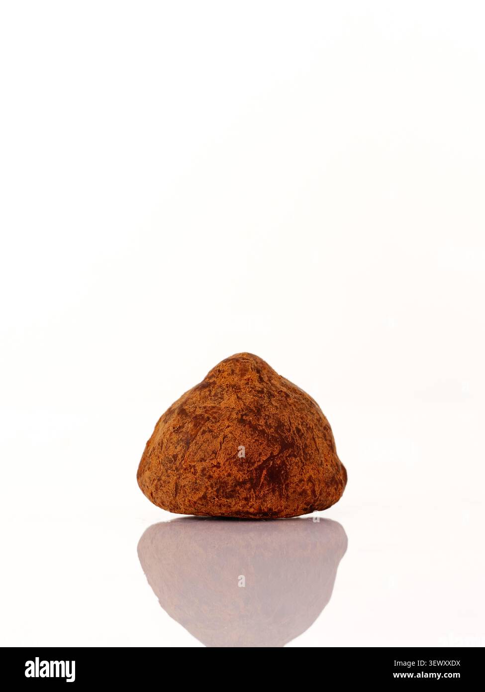 Single chocolate truffle with reflection on white Stock Photo