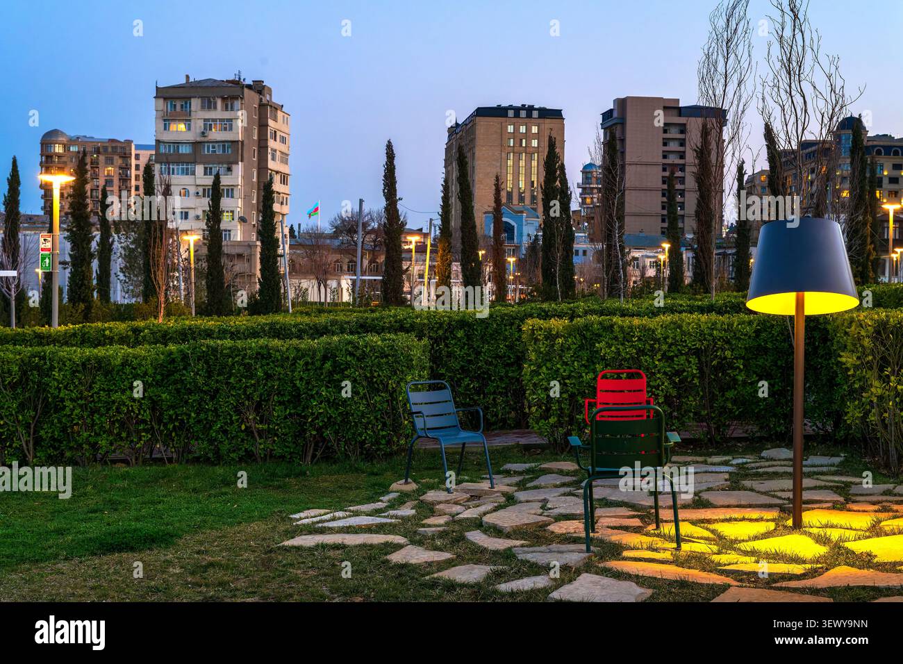 Topiary hedge labyrinth with coloured chairs and cypress trees at blue hour in Merkezi Park, Baku, Azerbaijan. Stock Photo