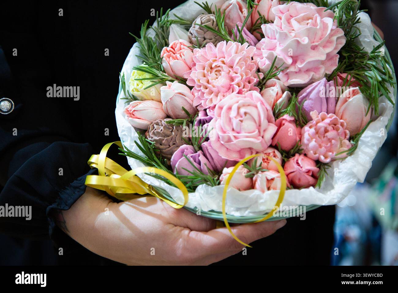 Bright Floral Bouquet Handoff. Courier Presenting Vibrant Pink Flowers Wrapped With Yellow Ribbon Stock Photo