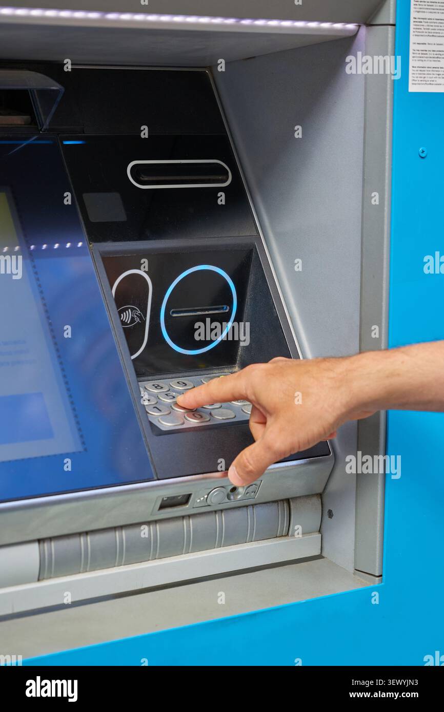 Human hand enters the PIN code on the ATM keyboard Stock Photo