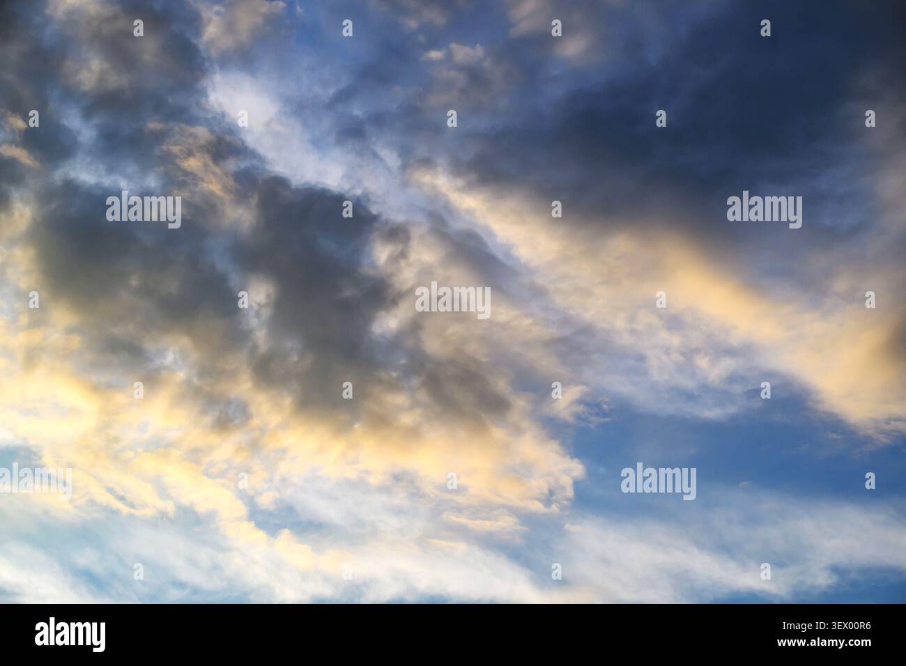 Dramatic sky with dark clouds and golden sunlight breaking through Stock Photo