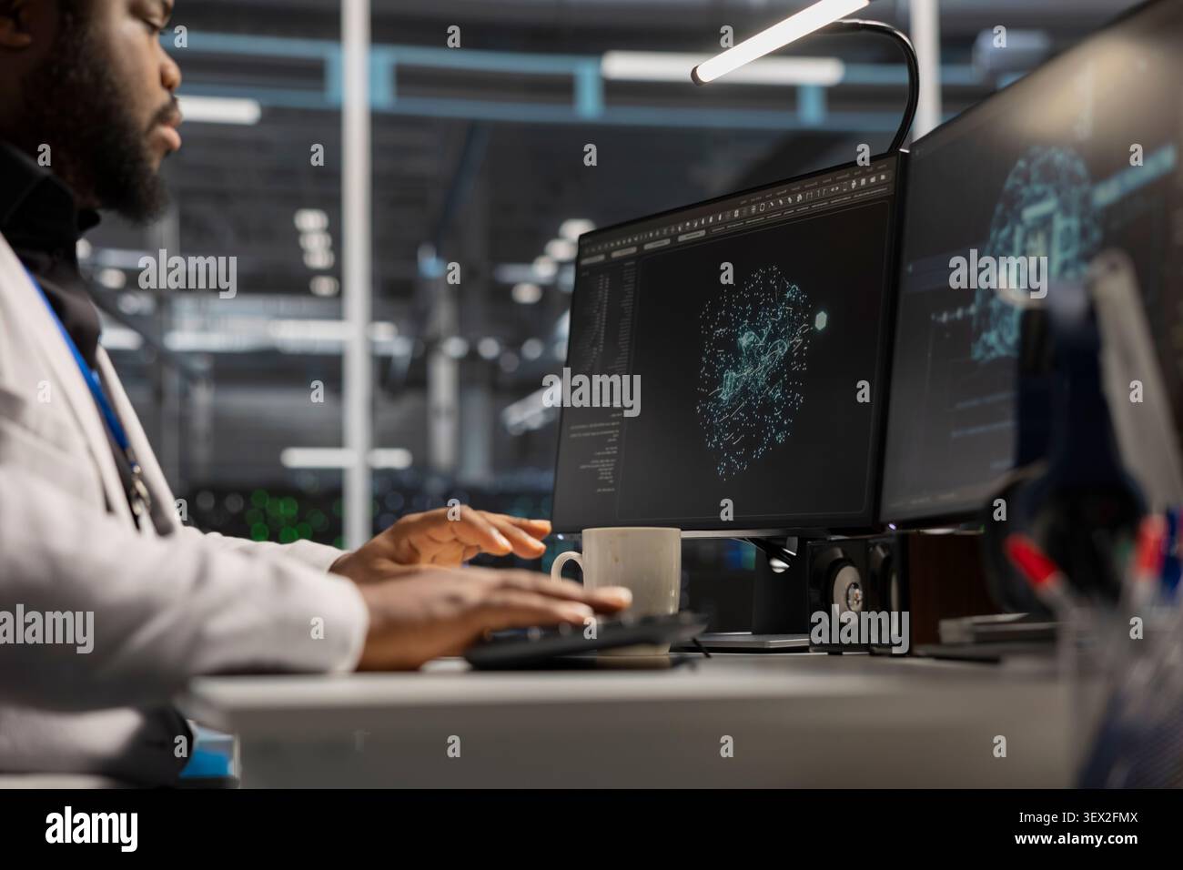 IT expert uses a desktop computer in a data center to support supercomputer management and reliable server workflows. Stock Photo