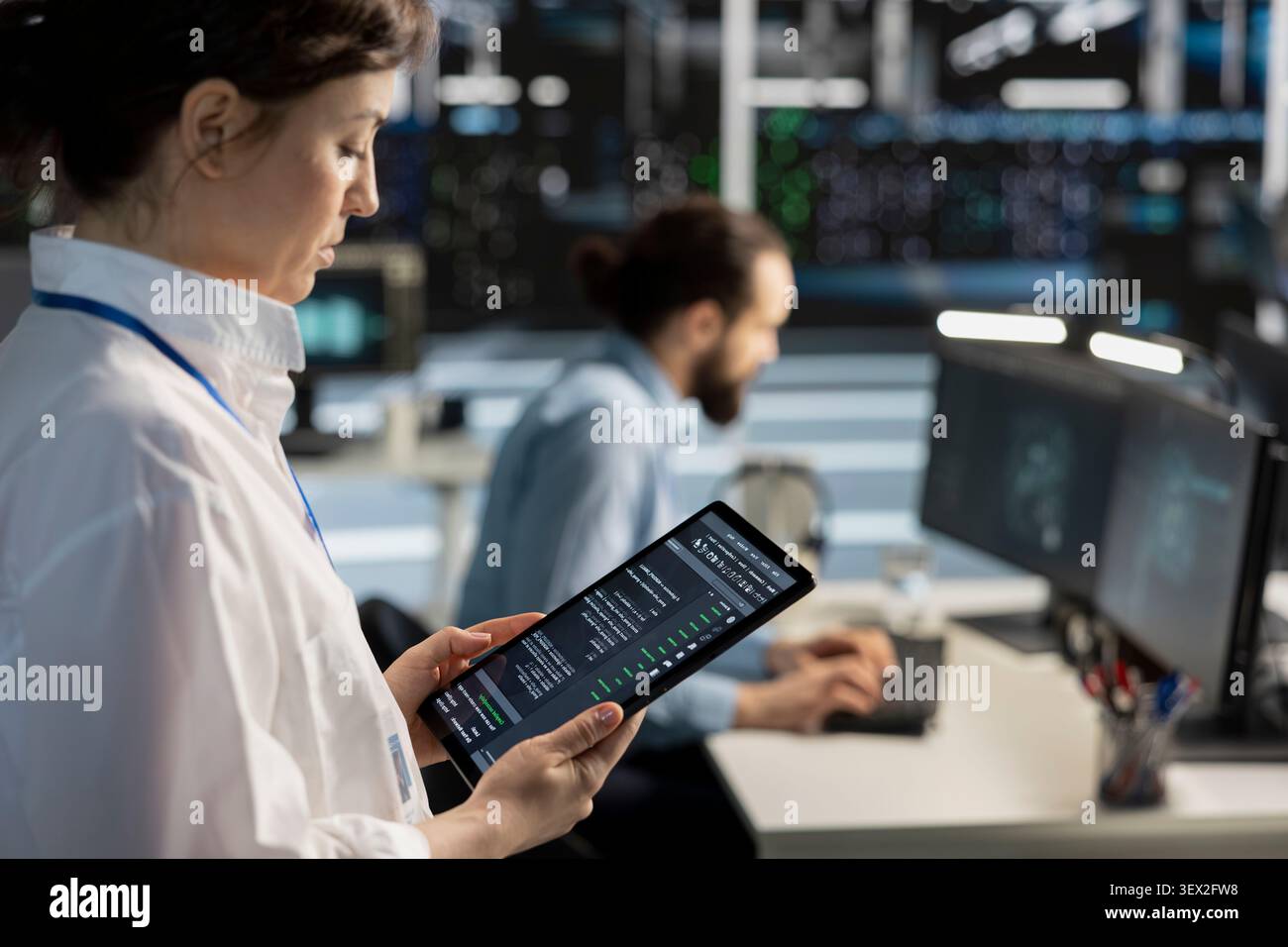 Data center programmer uses a digital tablet in a data center to support failure detection and reliable server workflows. Stock Photo