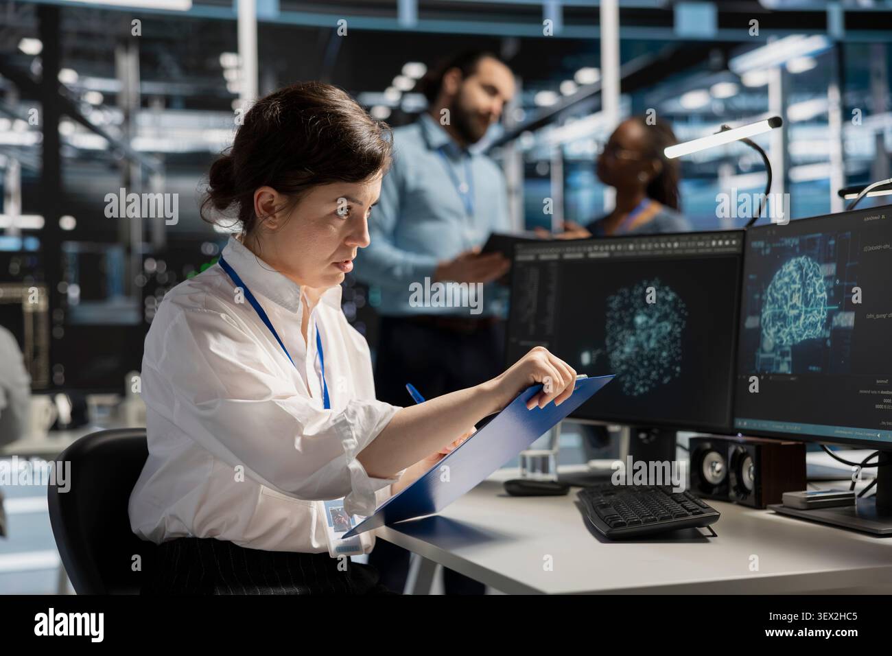 Server room worker uses a clipboard in a data center to manage AI visualization and optimize server infrastructure. Stock Photo