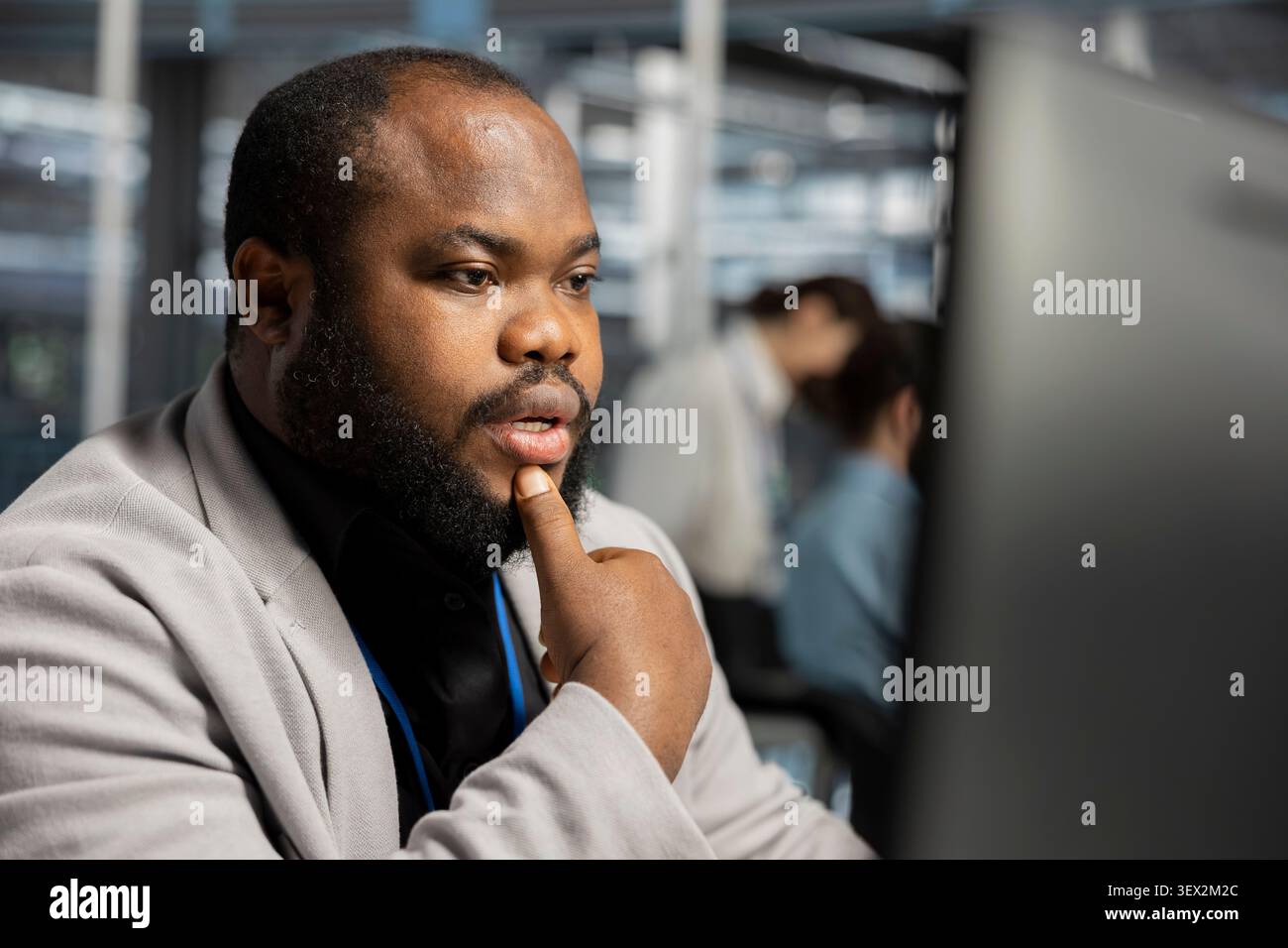 IT specialist uses a computer to run diagnostics, update servers and check infrastructure performance. Stock Photo
