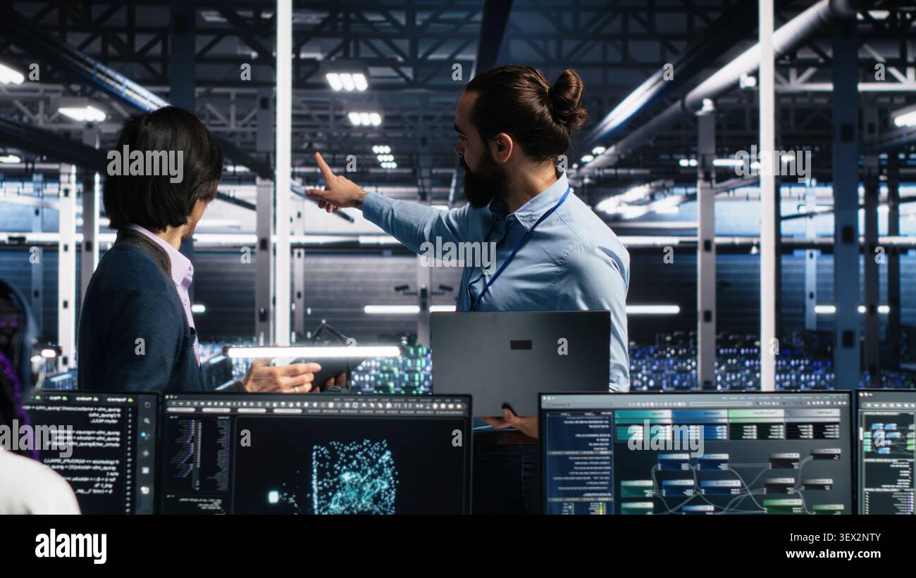 IT colleagues collaborate in a data center while reviewing AI diagnostics and infrastructure performance. Stock Photo