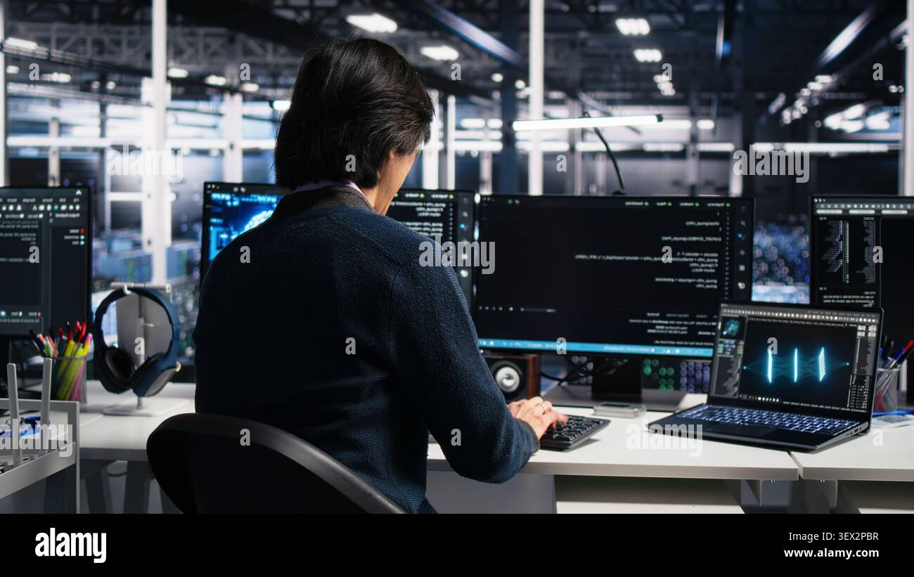 Administrator programs on a computer workstation in a high tech data center with generative AI assistance. Stock Photo