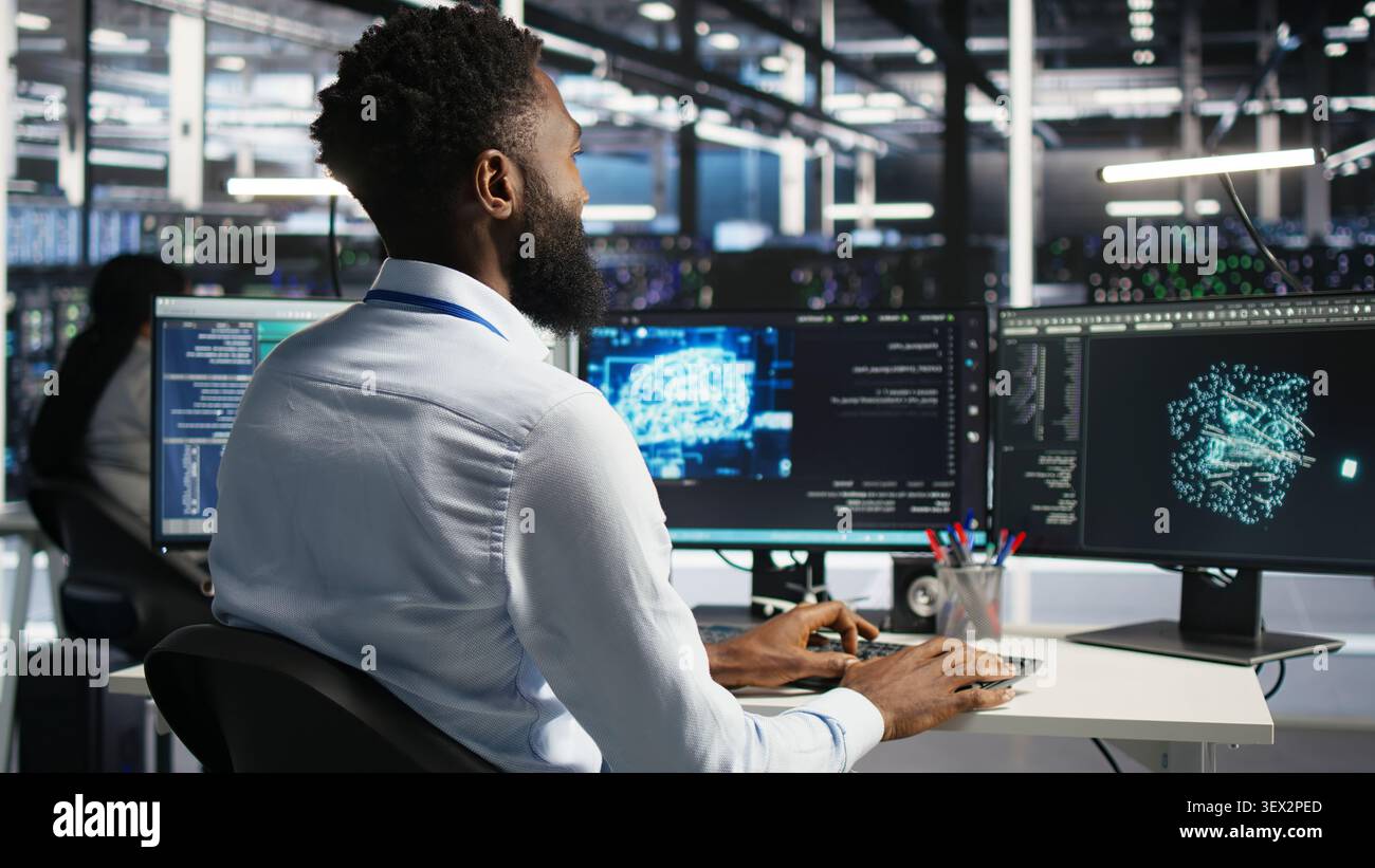 Computing hub engineering team interprets AI generated data analytics graphs, while teamworking server facility team members working with AI program showing predictive system metrics. Stock Photo