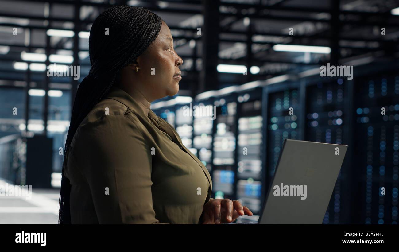 Technical specialist working with notebook computer in advanced technology server facility, integrating new technologies and systems. Stock Photo
