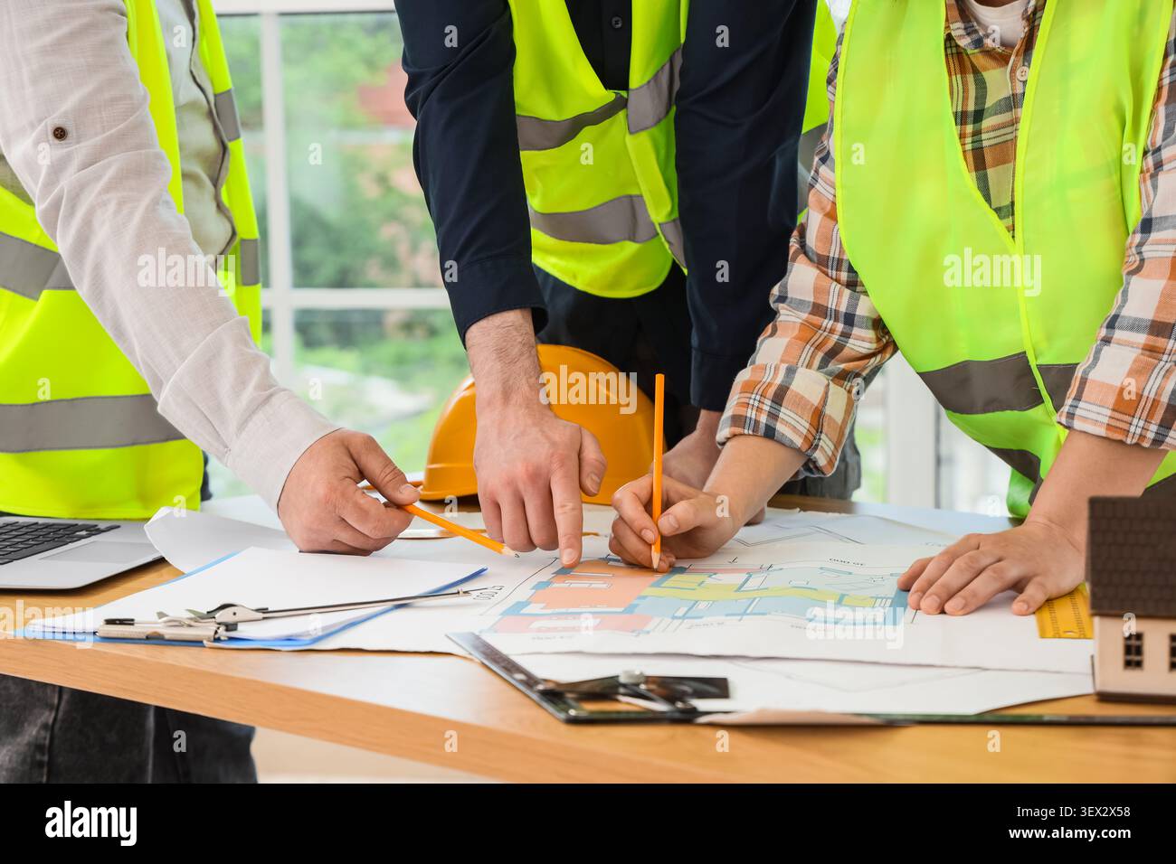 Construction workers collaborating on building plans Stock Photo